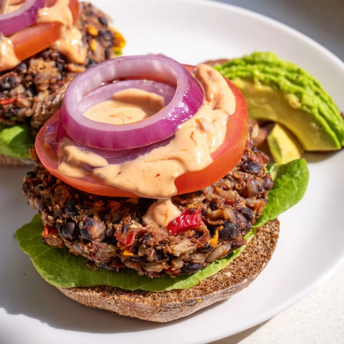 Freshly cooked Vegan Black Bean Burger patties sizzling in a skillet, their edges browned and crispy, ready to be assembled into a hearty meal.