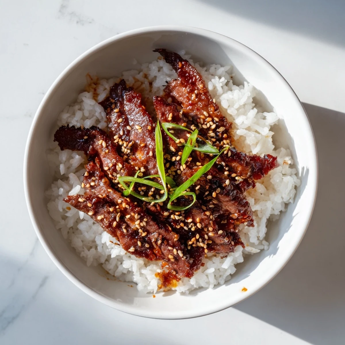 A close-up of sizzling Spicy Korean Beef Bowl with tender beef slices, cucumber, and radishes, served over warm jasmine rice.