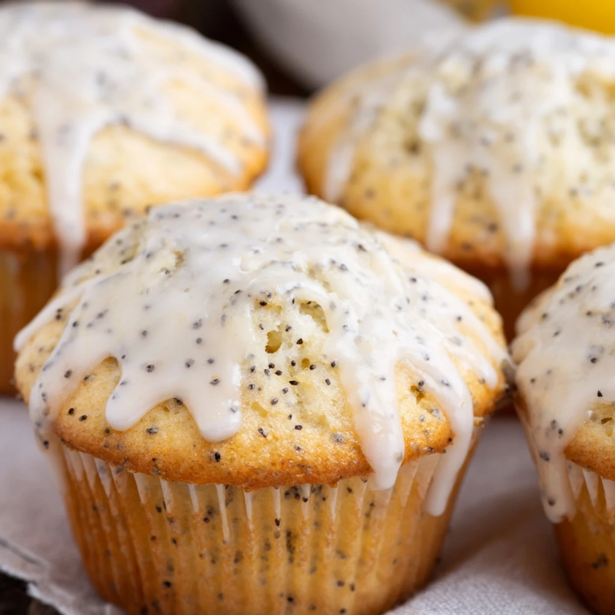 Freshly baked Lemon Poppy Seed Muffins with Glaze cooling on a wire rack, showing a tender crumb and drizzled white icing.  
