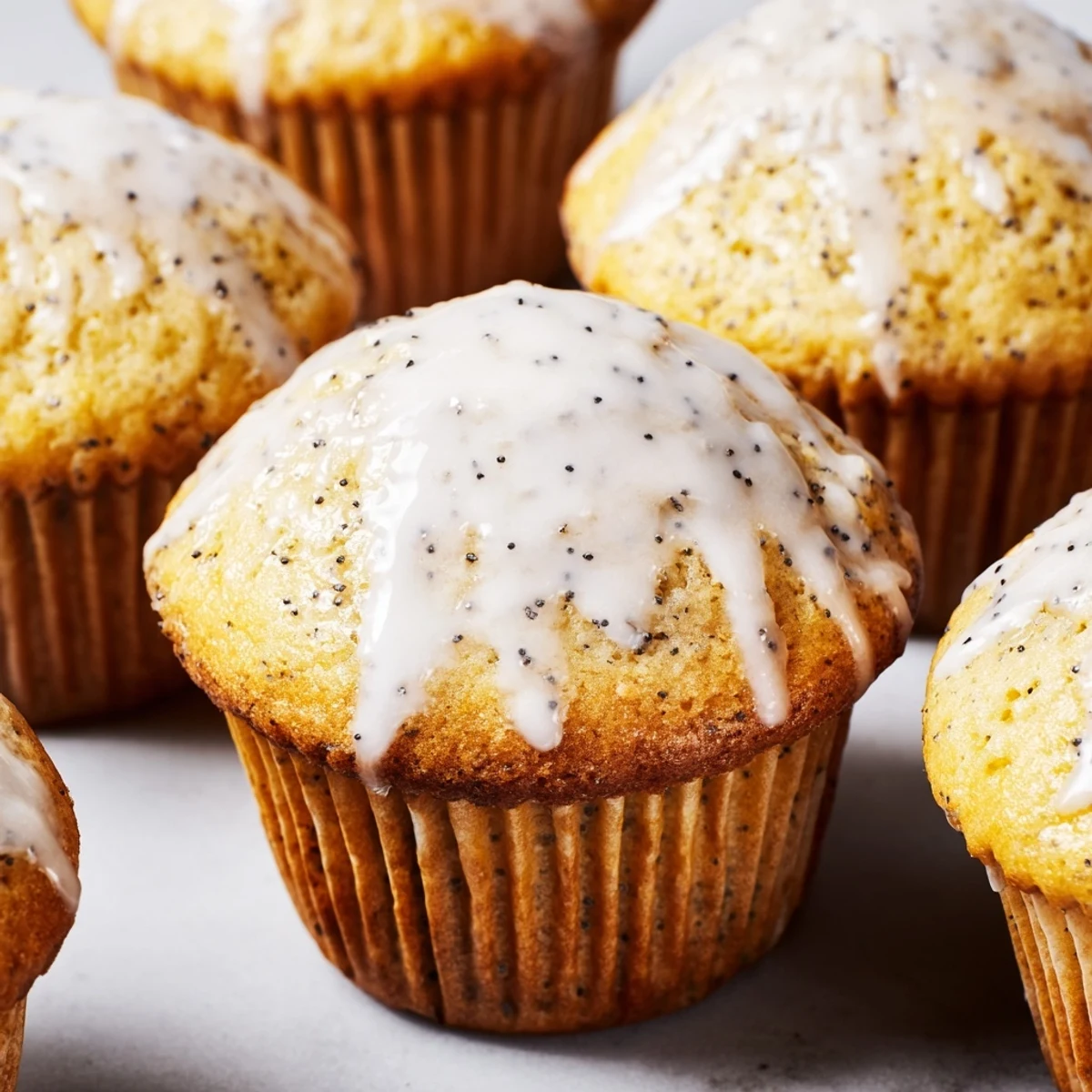 A close-up view of Lemon Poppy Seed Muffins with Glaze, highlighting the crunchy poppy seeds and glossy lemon topping.  