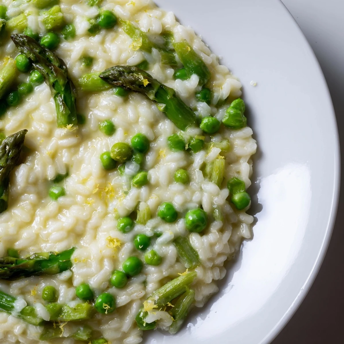 Steaming Creamy Spring Pea and Asparagus Risotto in a skillet, featuring a luscious texture with hints of lemon zest and rich butter.