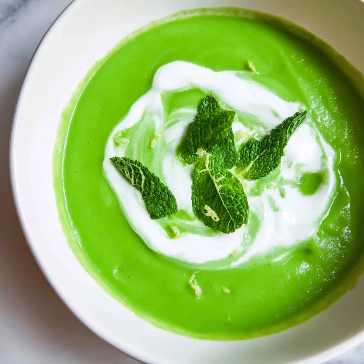 A close-up of Creamy Spring Pea and Mint Soup with Crème Fraîche showing its silky texture and vibrant spring colors.