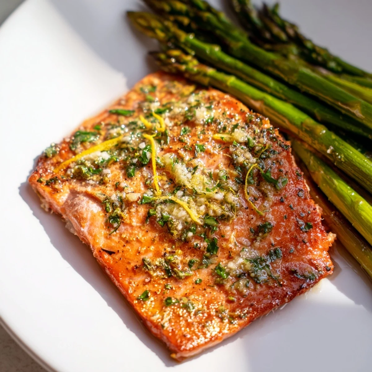 Flaky roasted salmon fillets and tender asparagus on a sheet pan, coated in fresh lemon and herbs, ready to serve.