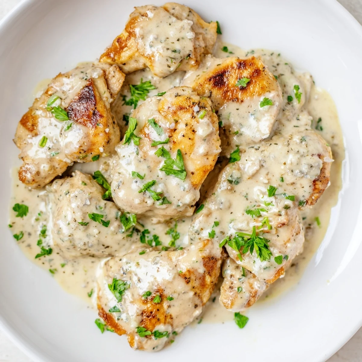 Golden-brown chicken breasts smothered in creamy Boursin Chicken sauce, garnished with fresh parsley.