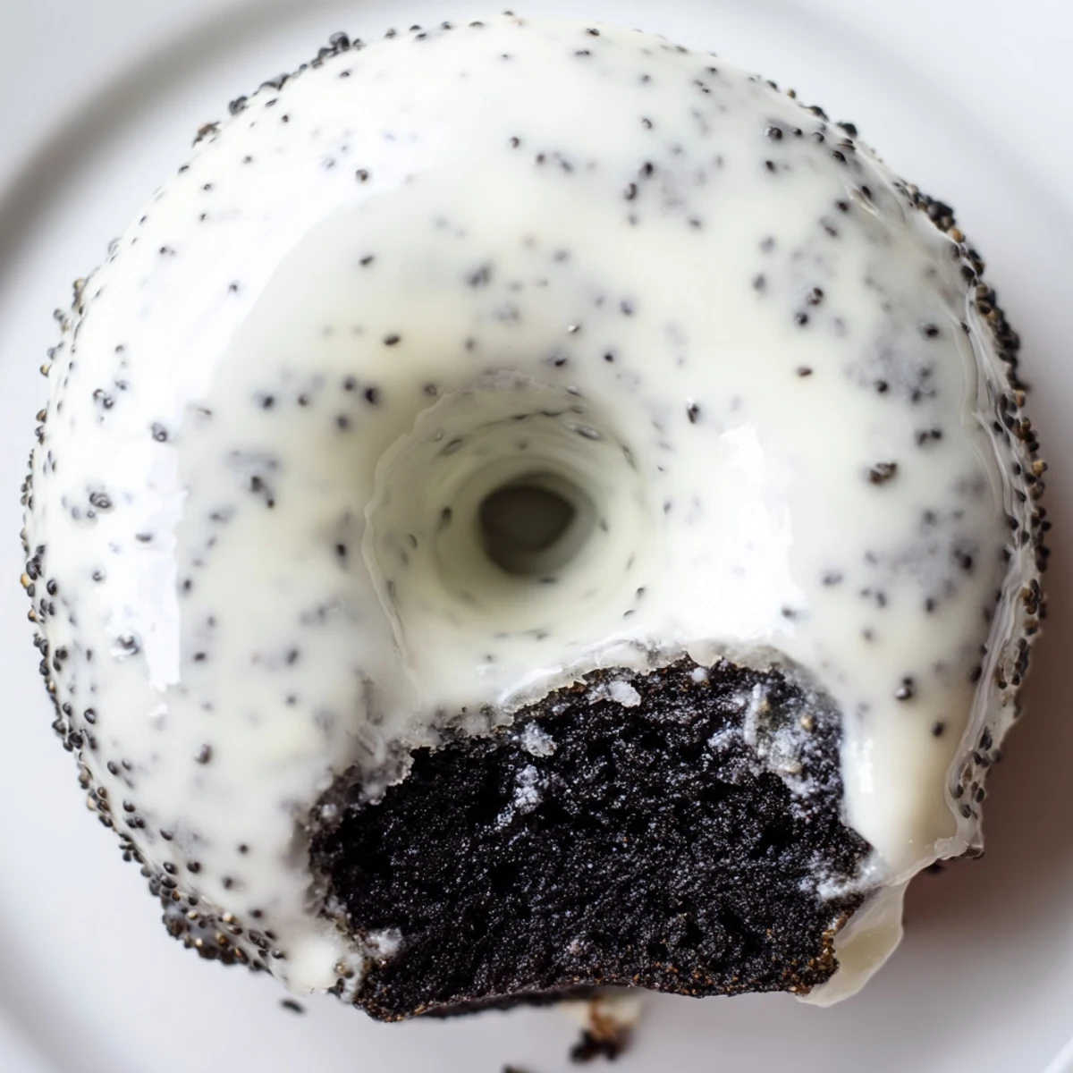 A close-up of Black Sesame Mochi Donuts on a wooden board, showing a crisp, glazed exterior and chewy interior.