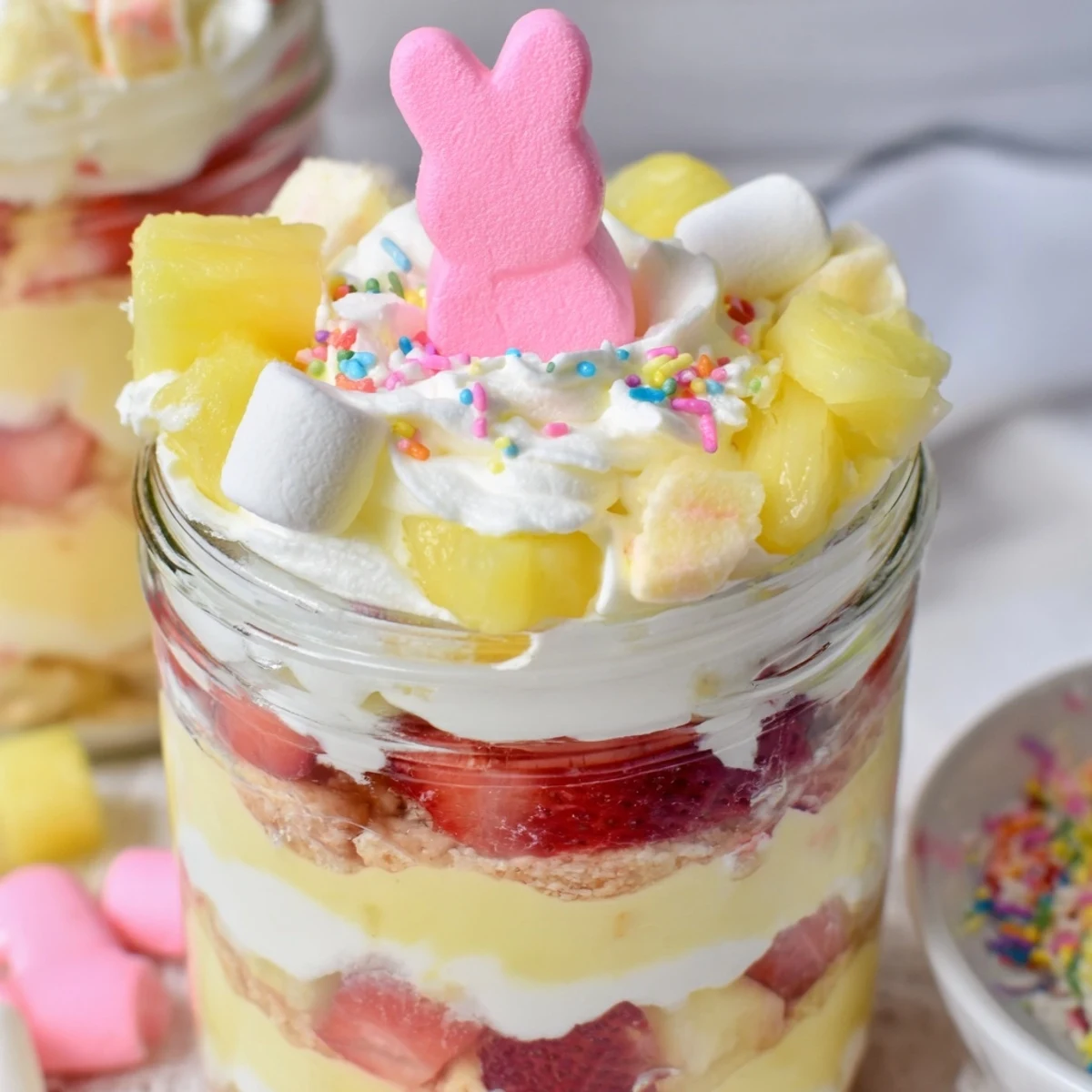 Serve these festive Jello Pie Easter Bunny Parfait In A Jar desserts topped with whipped cream and pastel sprinkles for a whimsical Easter celebration.