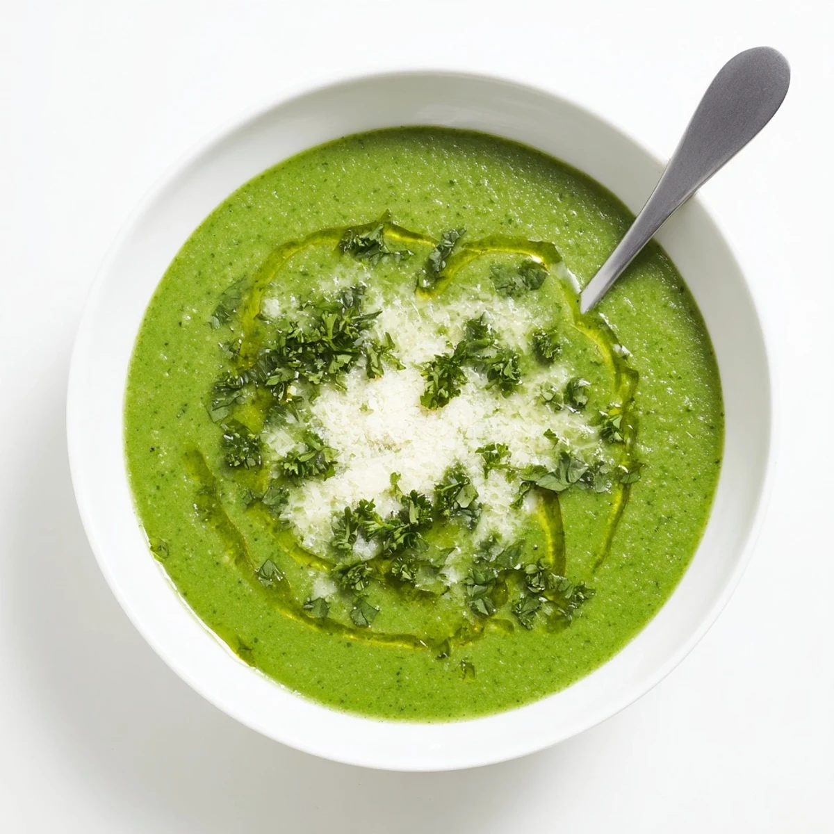 Steaming bowl of homemade Italian broccoli soup garnished with basil and extra Parmesan cheese on a wooden table