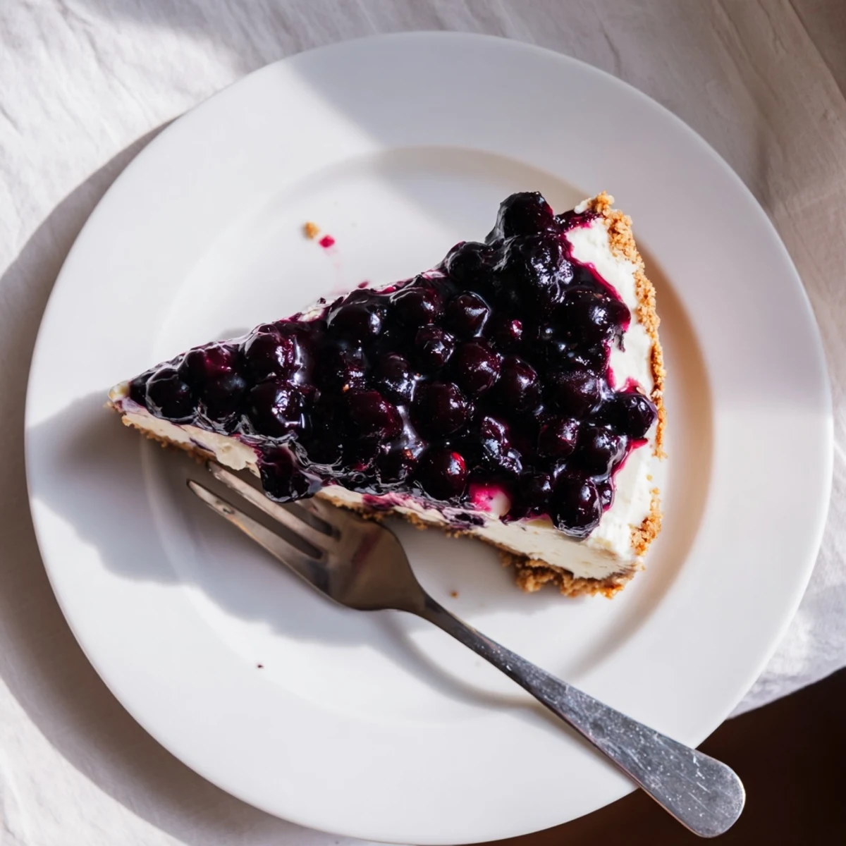 Homemade blueberry cheesecake with velvety cream cheese layer and luscious fruit topping on golden crust