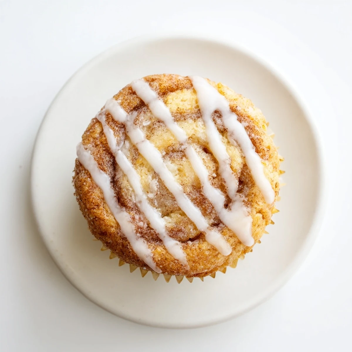 Freshly baked cinnamon roll protein muffins with gooey cinnamon centers and powdered sugar drizzle