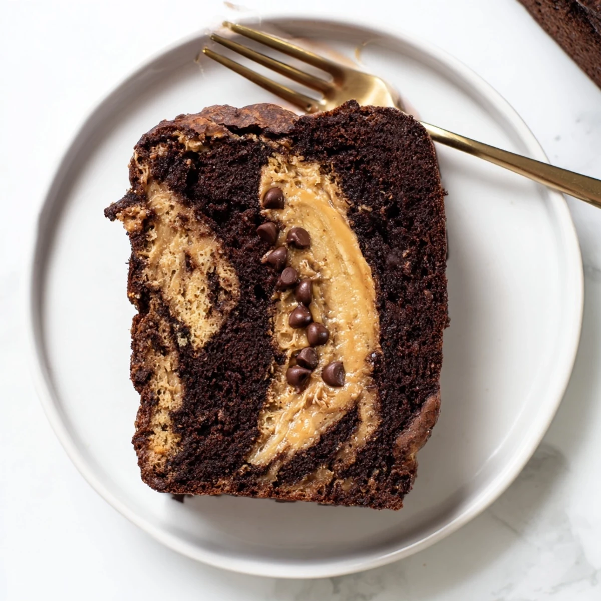 Golden slice of chocolate peanut butter banana bread with melty chips on a wooden board