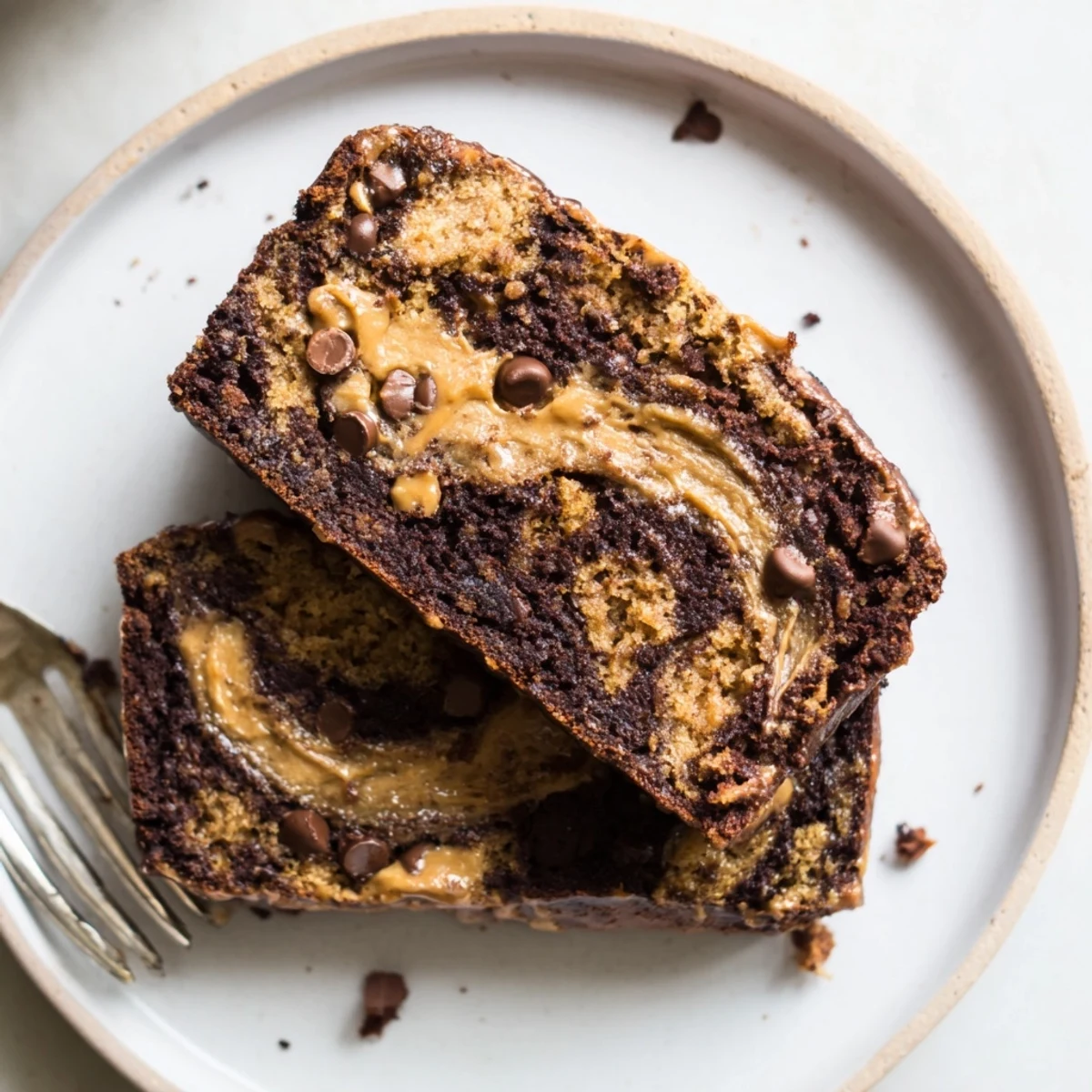 Thick slice of moist chocolate peanut butter banana bread drizzled with extra peanut butter sauce