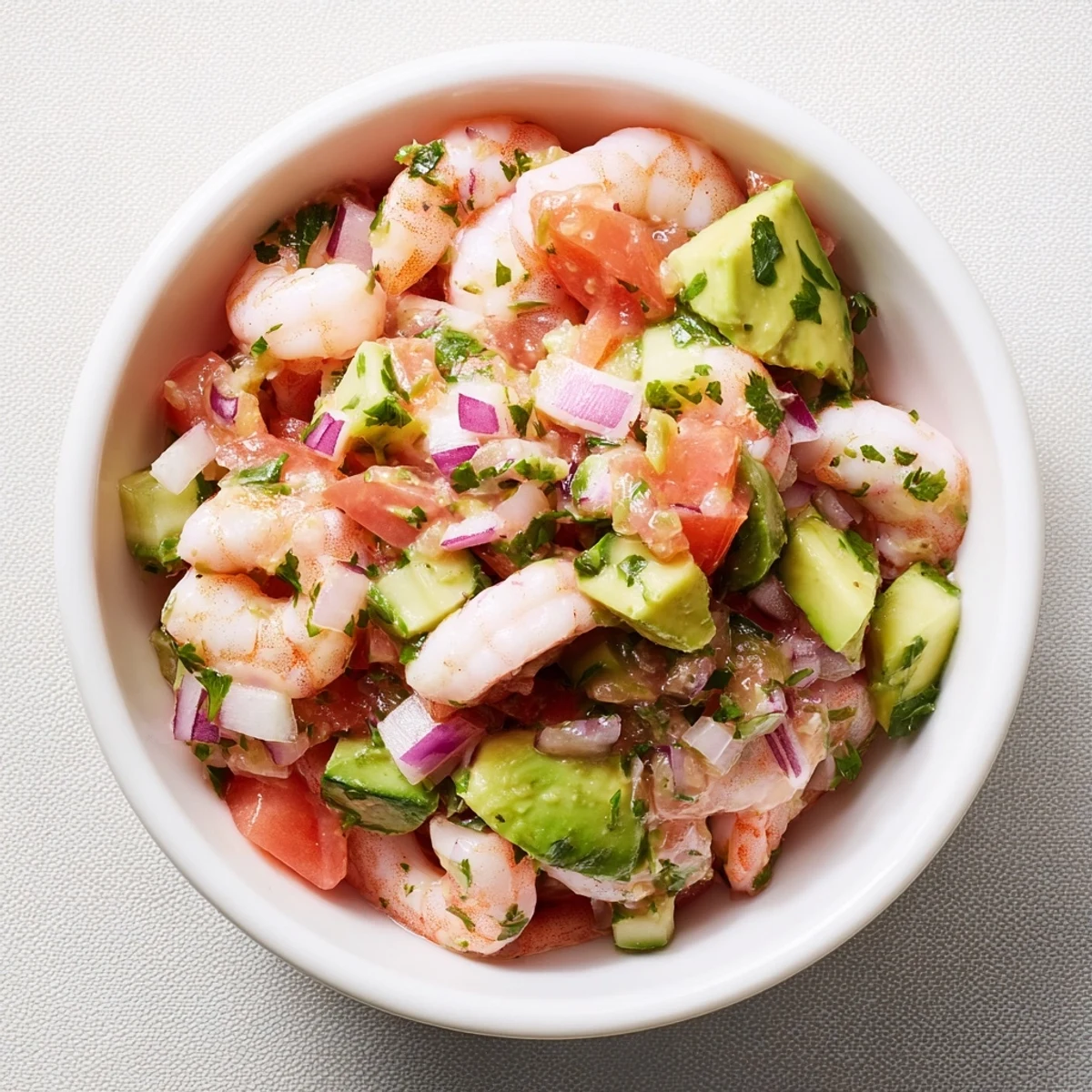 Chilled easy shrimp ceviche served in white bowl with crisp tortilla chips alongside