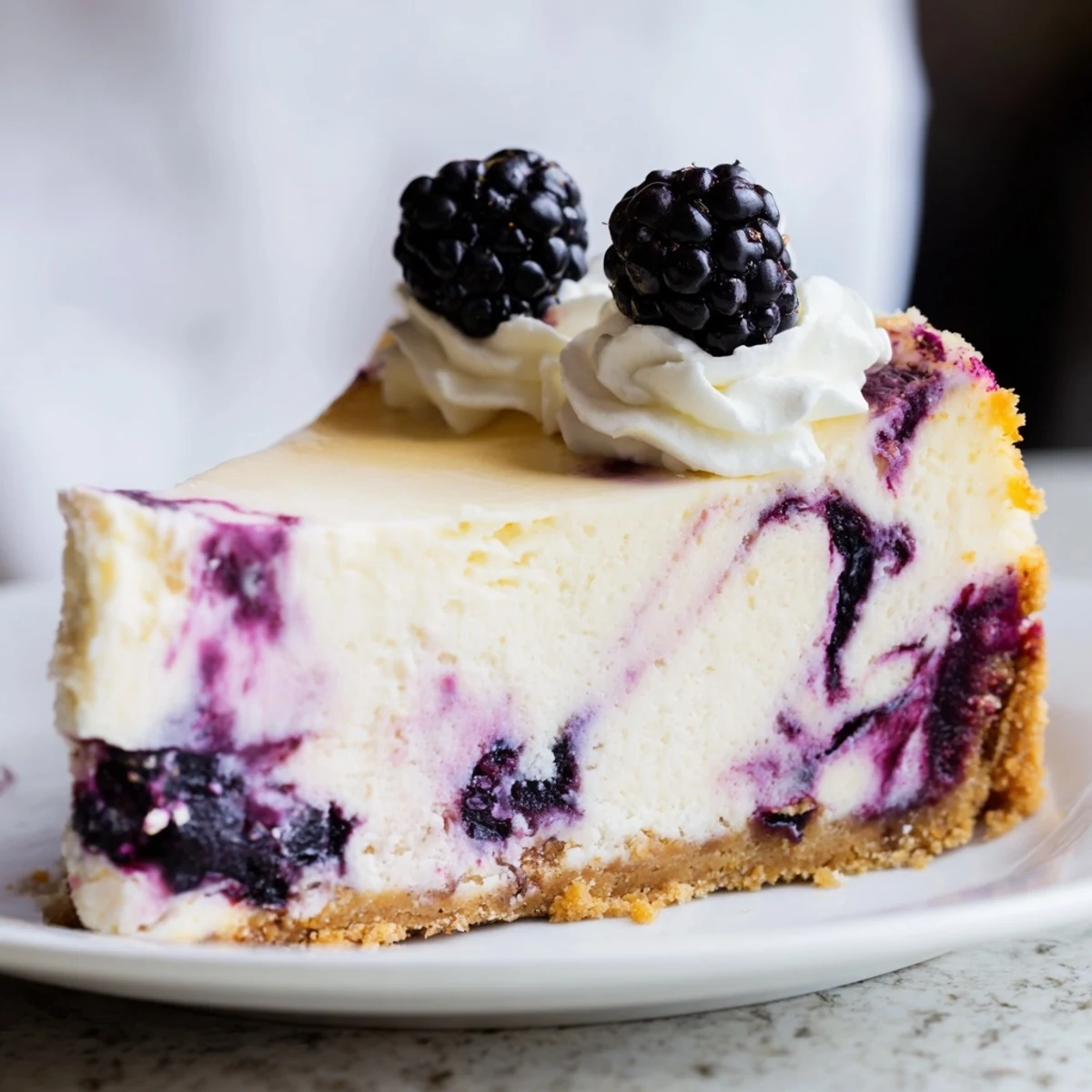 Decadent Blackberry Bliss Cheesecake with fresh berry garnish and whipped cream atop crisp buttery graham cracker base
