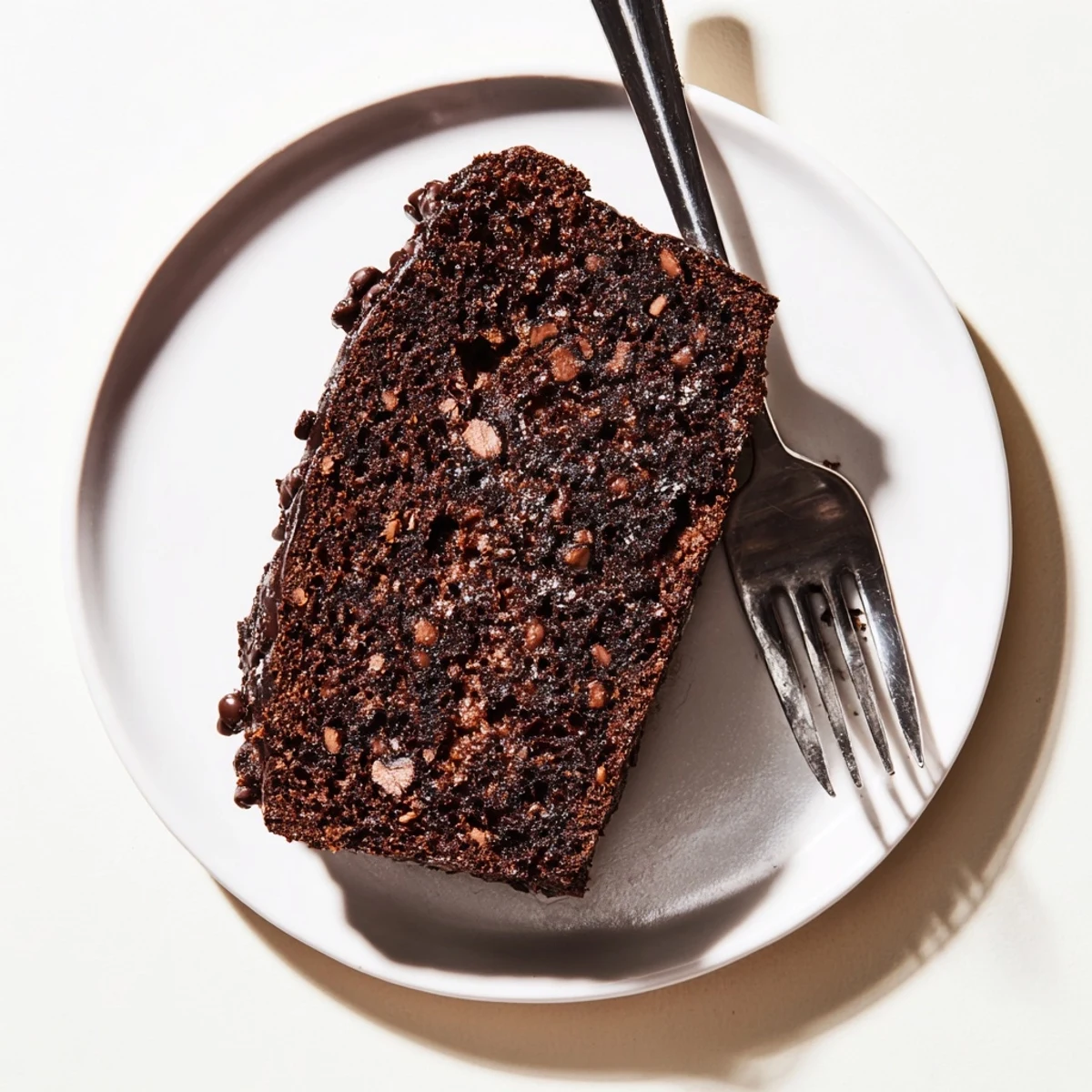 Moist chocolate espresso banana bread loaf studded with melted chocolate chips and sliced on a wooden board