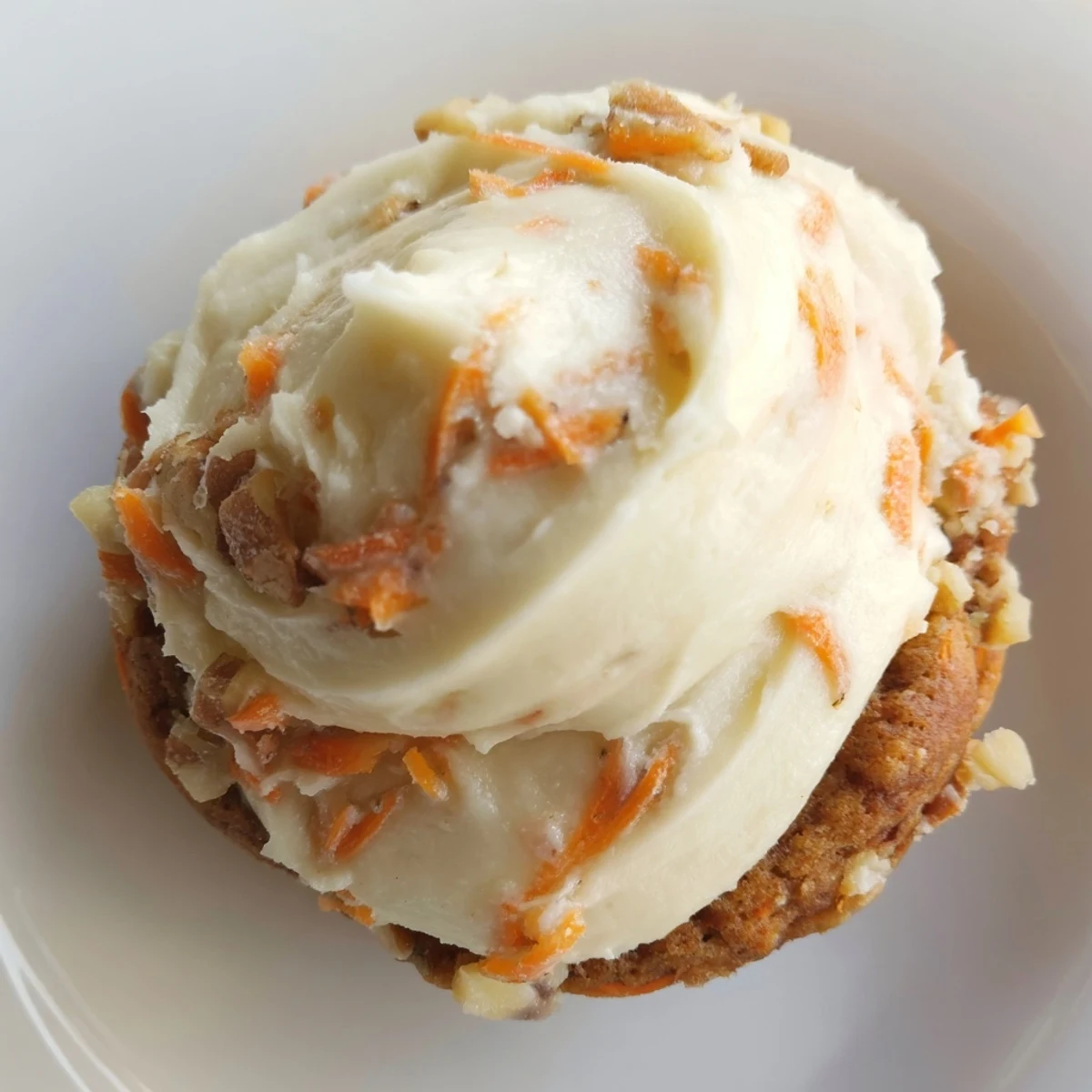 Soft frosted Crumbl carrot cake cookies with swirled cream cheese topping on rustic wooden board