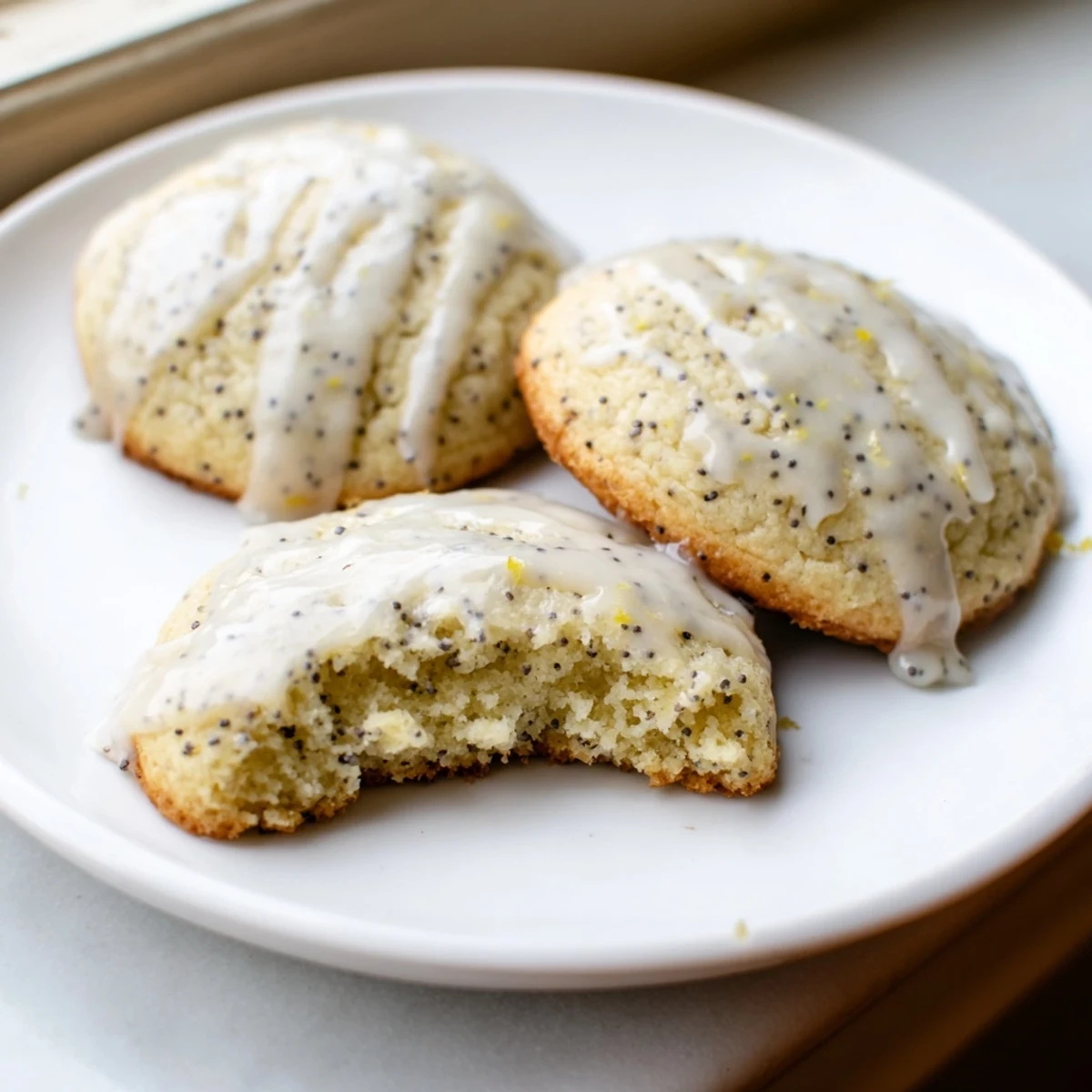 Chewy lemon poppy seed cookies drizzled with sweet citrus glaze on parchment paper