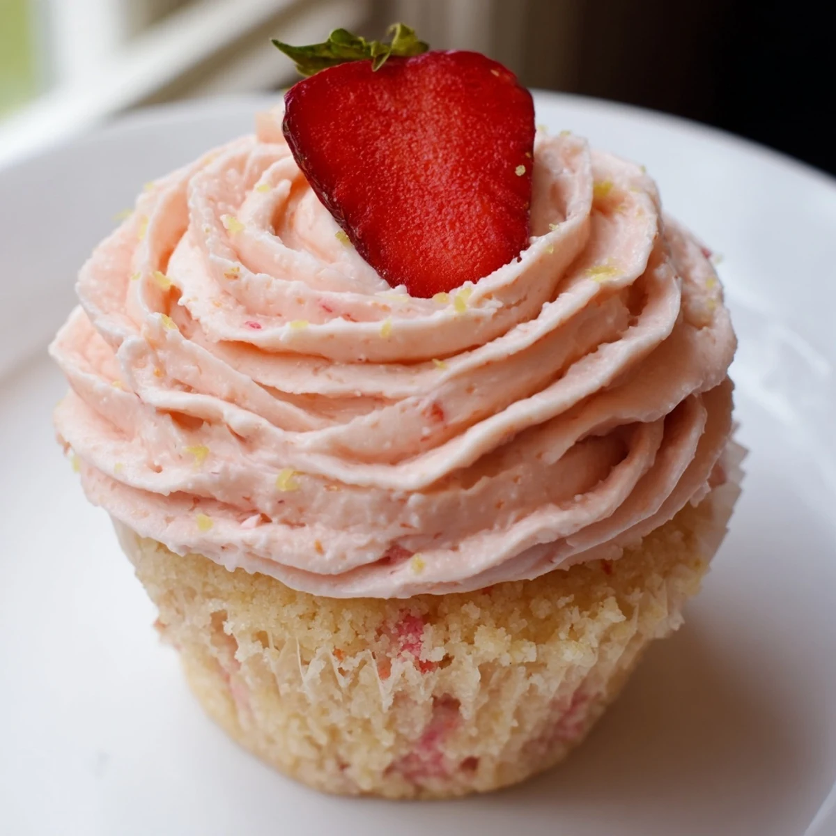 Golden strawberry lemonade cupcakes with fluffy lemon strawberry buttercream piled high and fresh berry garnish