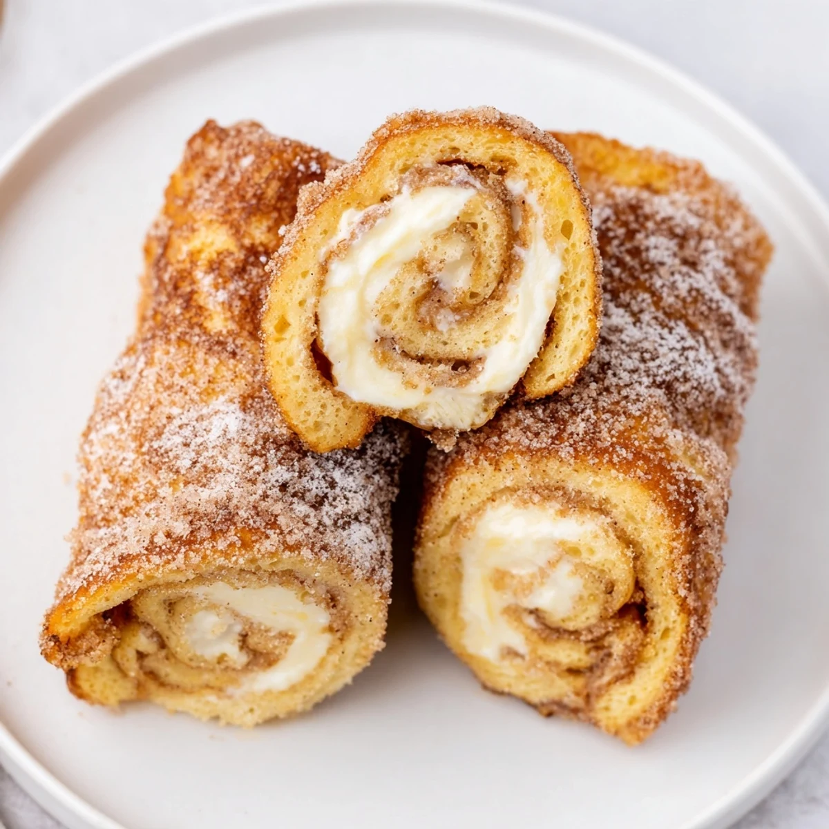 Skillet browned Cinnamon Roll French Toast Roll Ups, dusted with powdered sugar