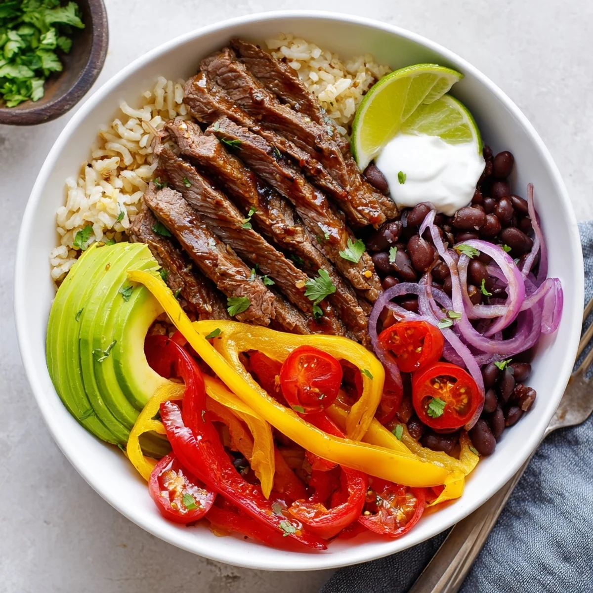 Steak Fajita Power Bowls with sizzling steak, charred peppers, creamy avocado, lime