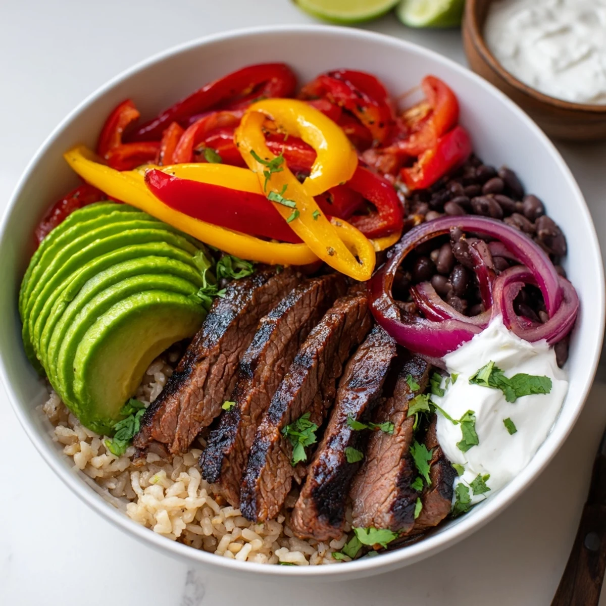 Hearty Steak Fajita Power Bowls served warm with tangy lime wedges and yogurt