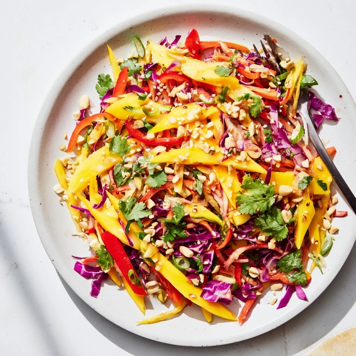 Golden mango slaw topped with toasted sesame seeds and fresh cilantro, perfect light side dish for summer meals