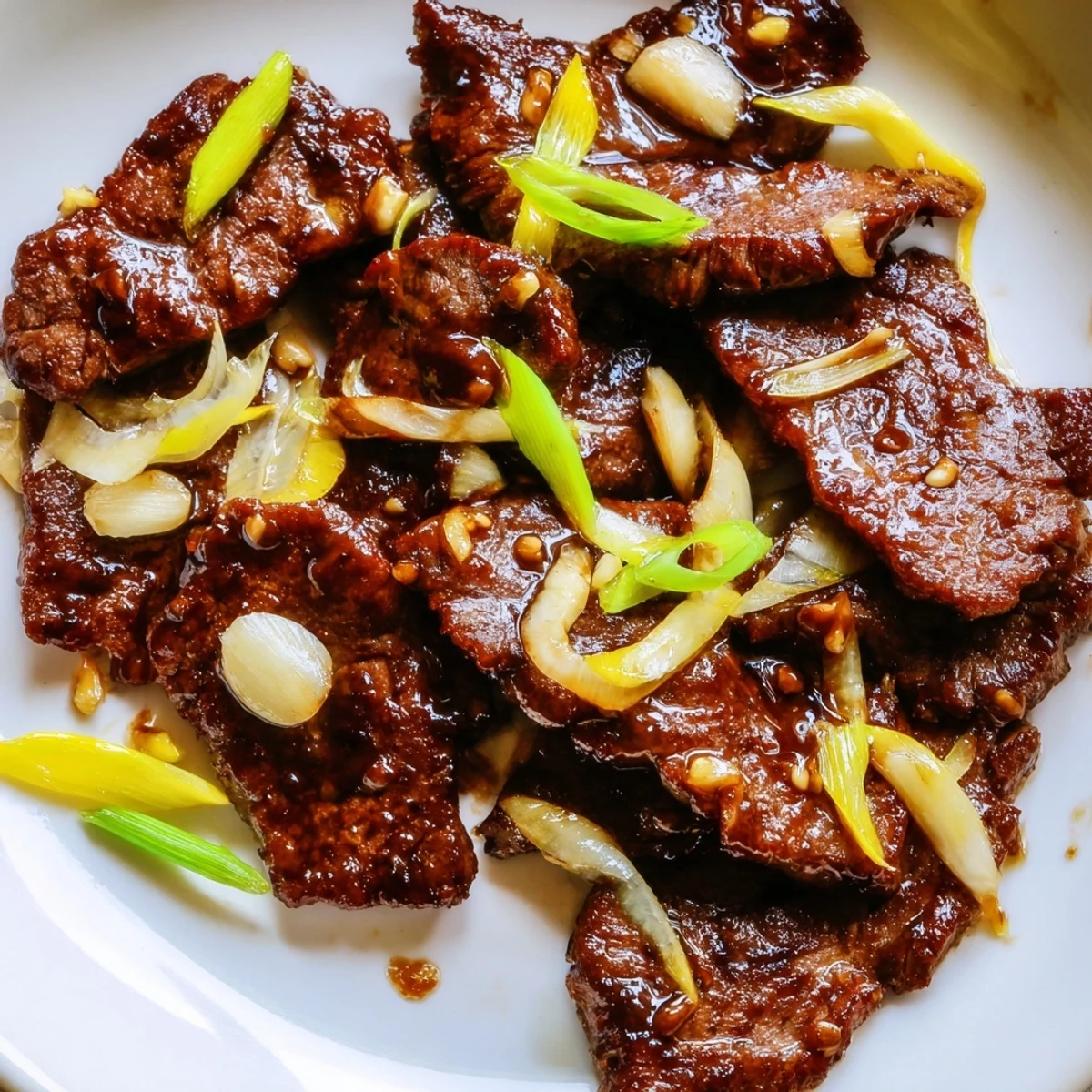 Tender beef slices with sweet onions in a Chinese-inspired stir fry over steaming rice