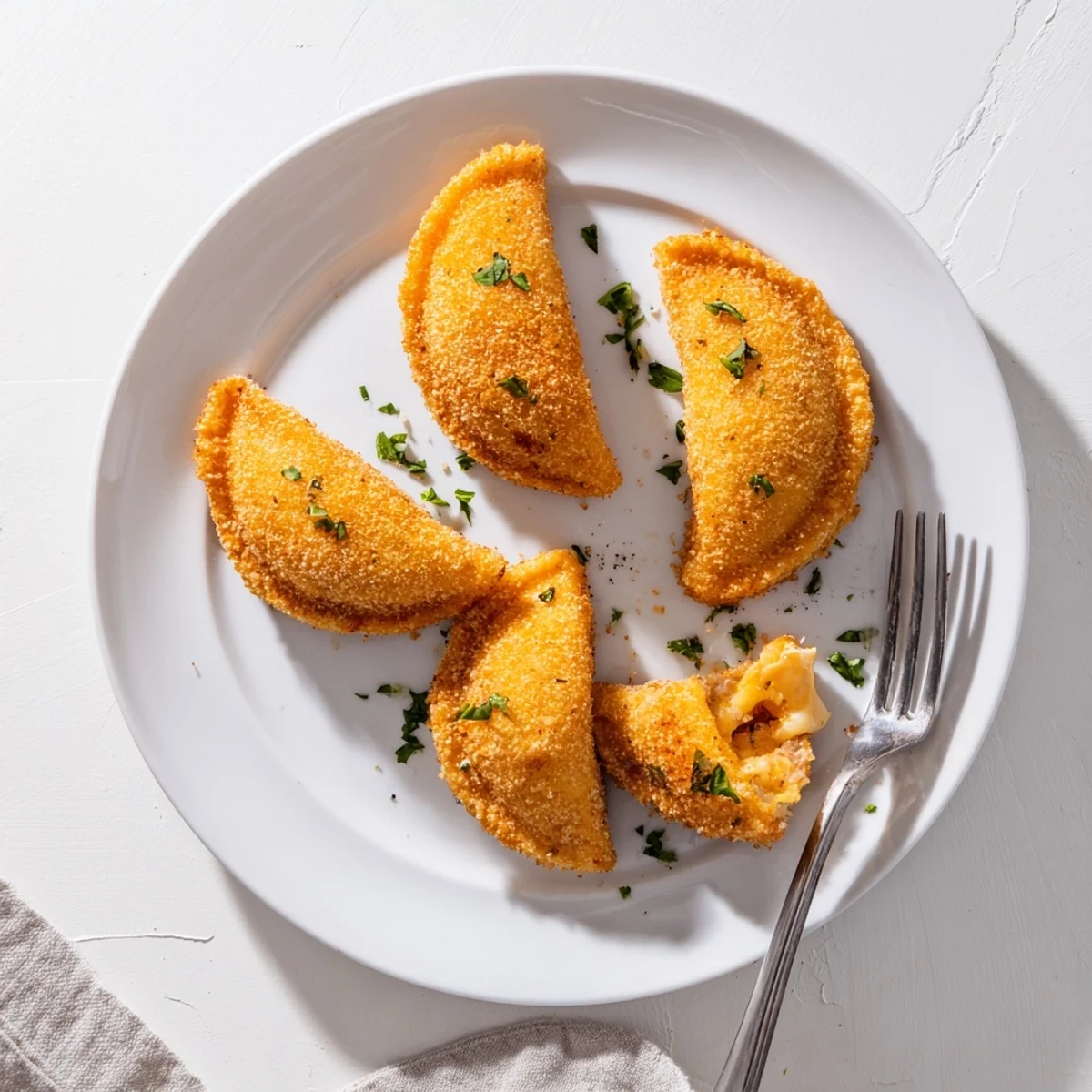 Golden Portuguese shrimp rissois with crispy breadcrumbs and creamy shrimp filling on a white serving plate