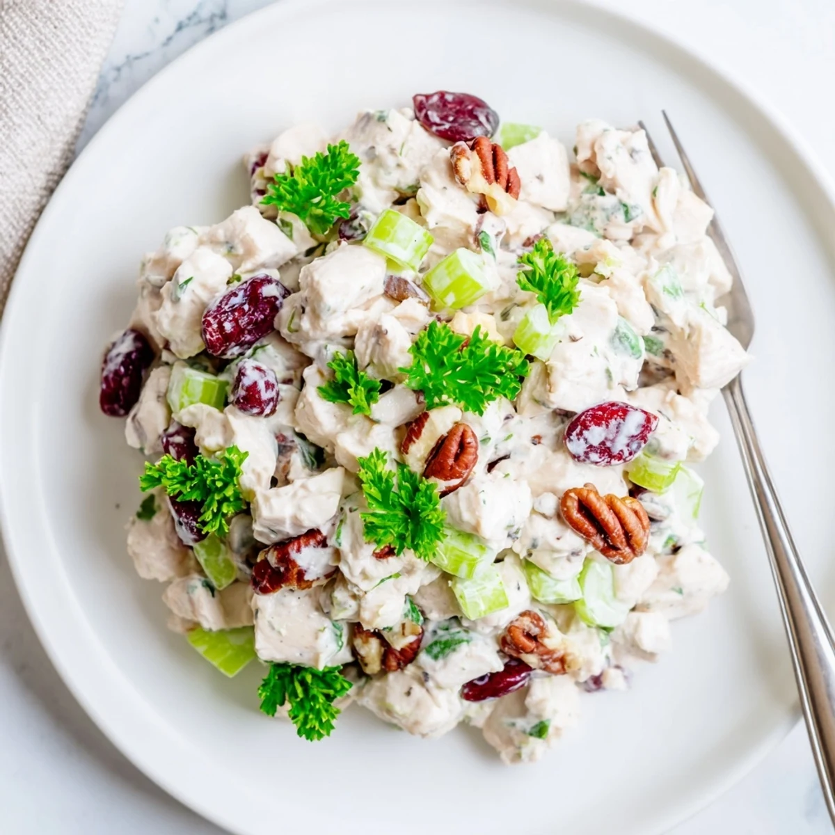 Creamy cranberry pecan chicken salad plated with fresh celery and green onions