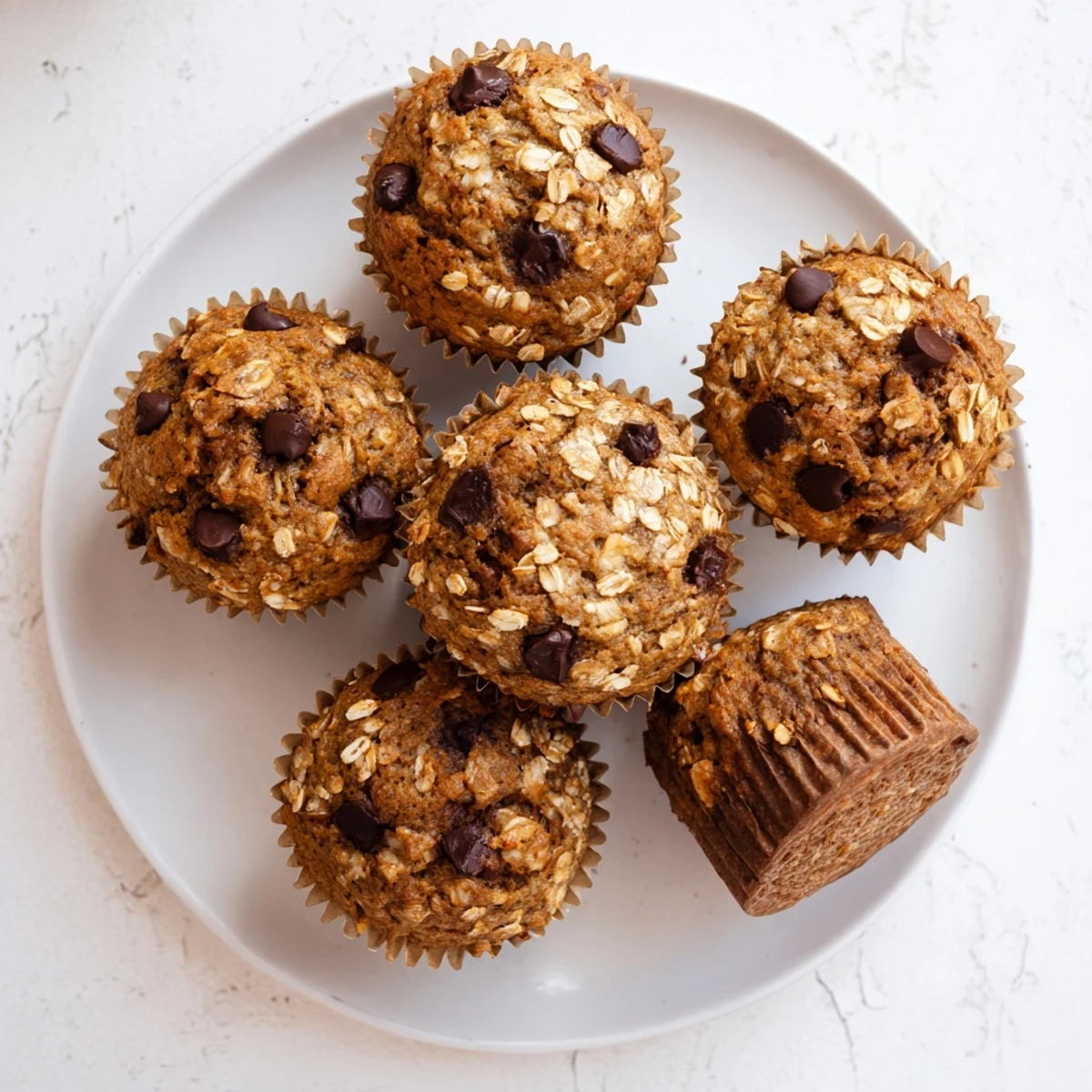 Soft moist banana chocolate chip muffins with oats sprinkled on top ready for breakfast or snacking