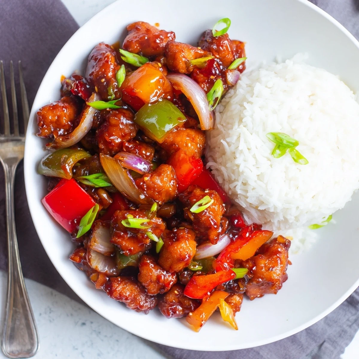 Crispy, saucy Flavorful Chilli Chicken served hot with jasmine rice and scallions