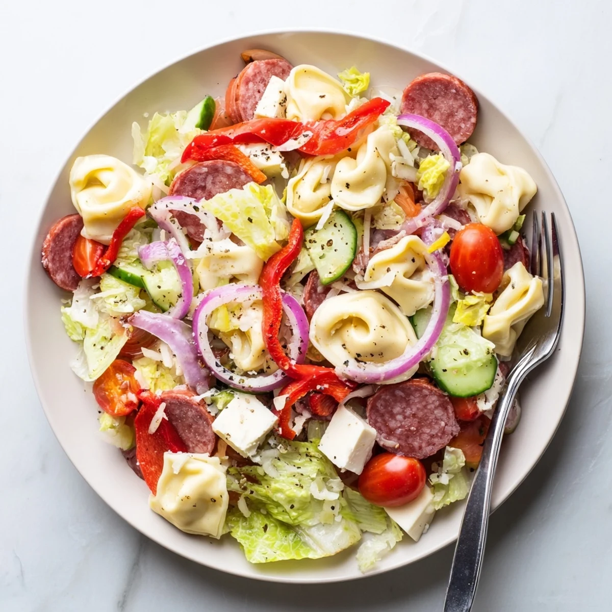 Colorful bowl of fresh grinder tortellini salad recipe loaded with vegetables, cheese, and zesty dressing