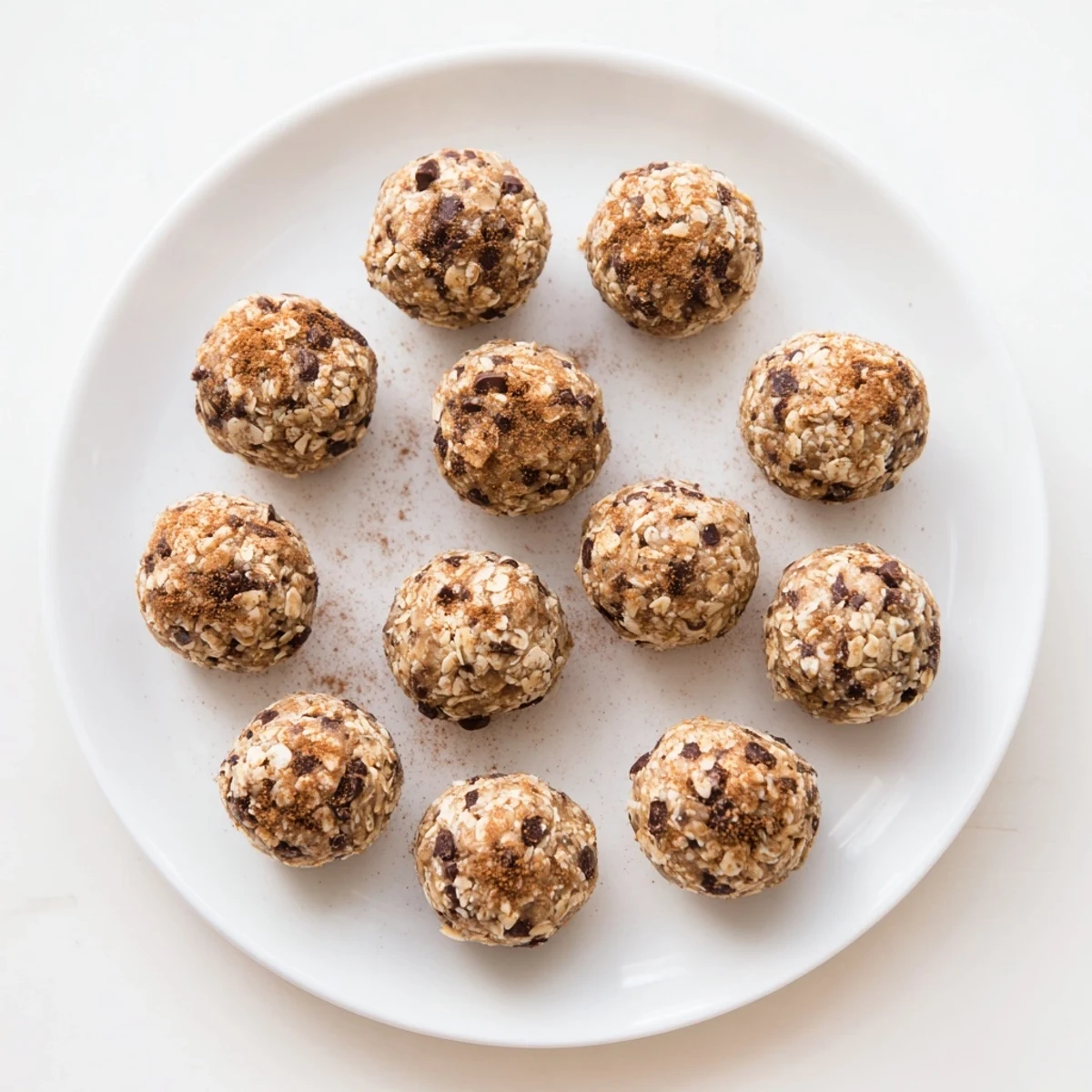 Bite-sized banana bread energy balls topped with chia seeds arranged on parchment paper for easy storage