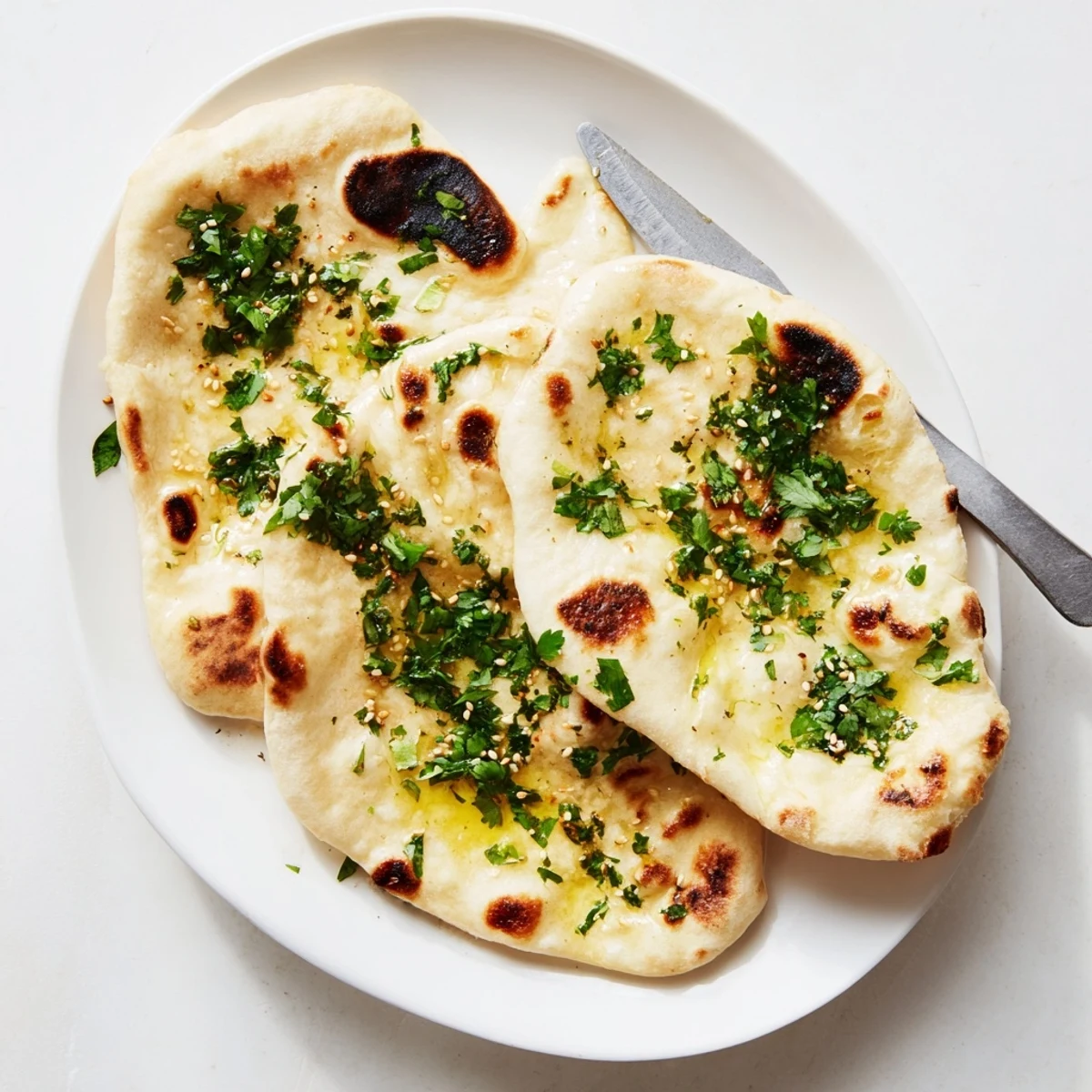 Pillowy Indian-style sourdough discard naan with charred bubbles perfect for scooping savory curries
