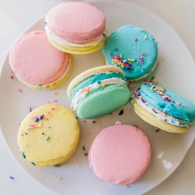 A close-up view of Pastel Sugar Cookie Sandwiches dusted with sprinkles, ready for an Easter dessert party.  