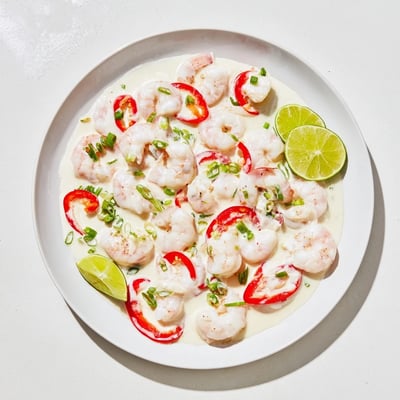 Tender shrimp in velvety coconut sauce fills a large platter, ready for a festive buffet line or family-style dinner.