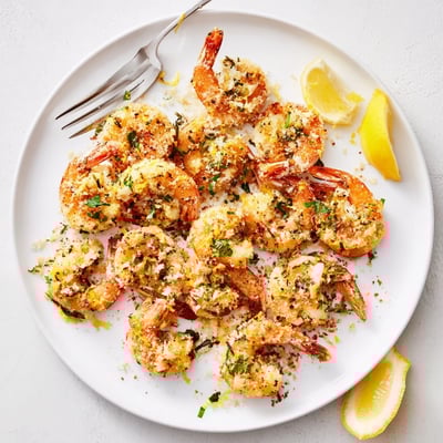 Savory Air Fryer Garlic Parmesan Shrimp piled high next to a green salad and crusty bread for dinner.